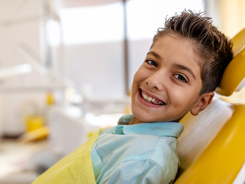 image of a boy smiling in a dental chair